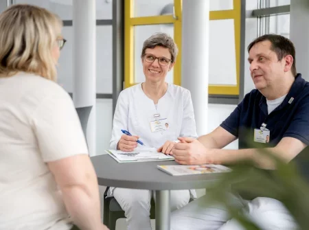 Zwei Ärzte und eine Patientin bei einer Besprechung |